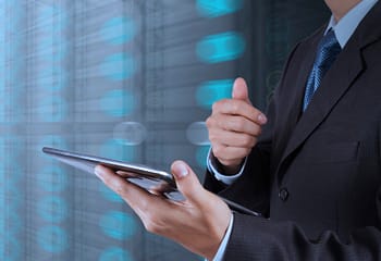 businessman hand using tablet computer and server room backgroun